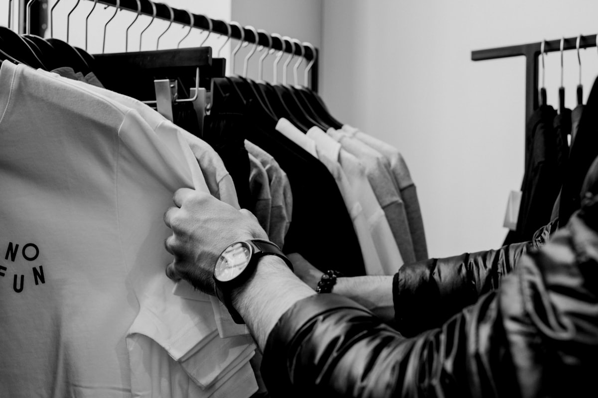 A small retailer working at a clothing rail